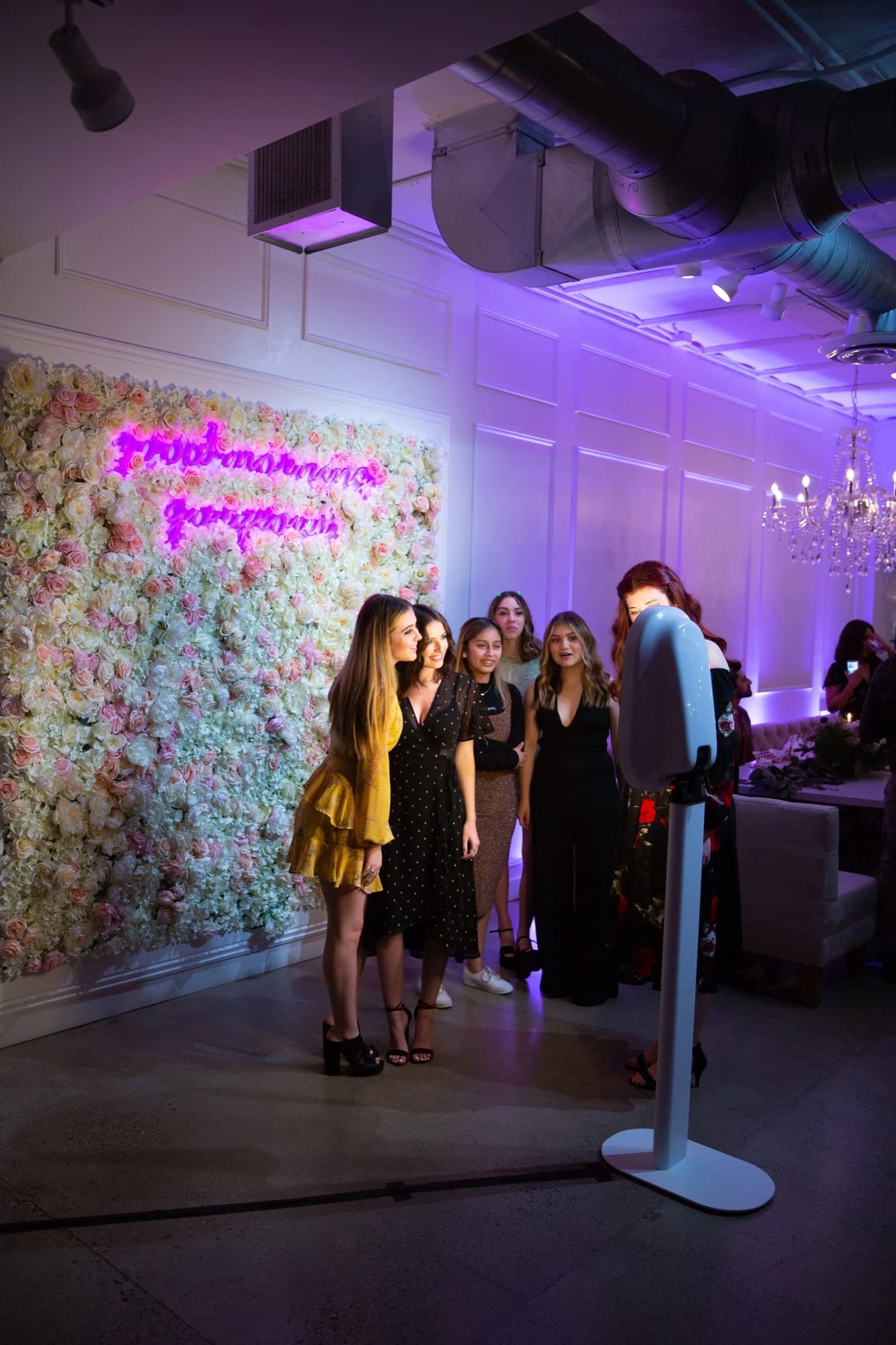 Guests at the Lyric photo booth in front of a flower wall