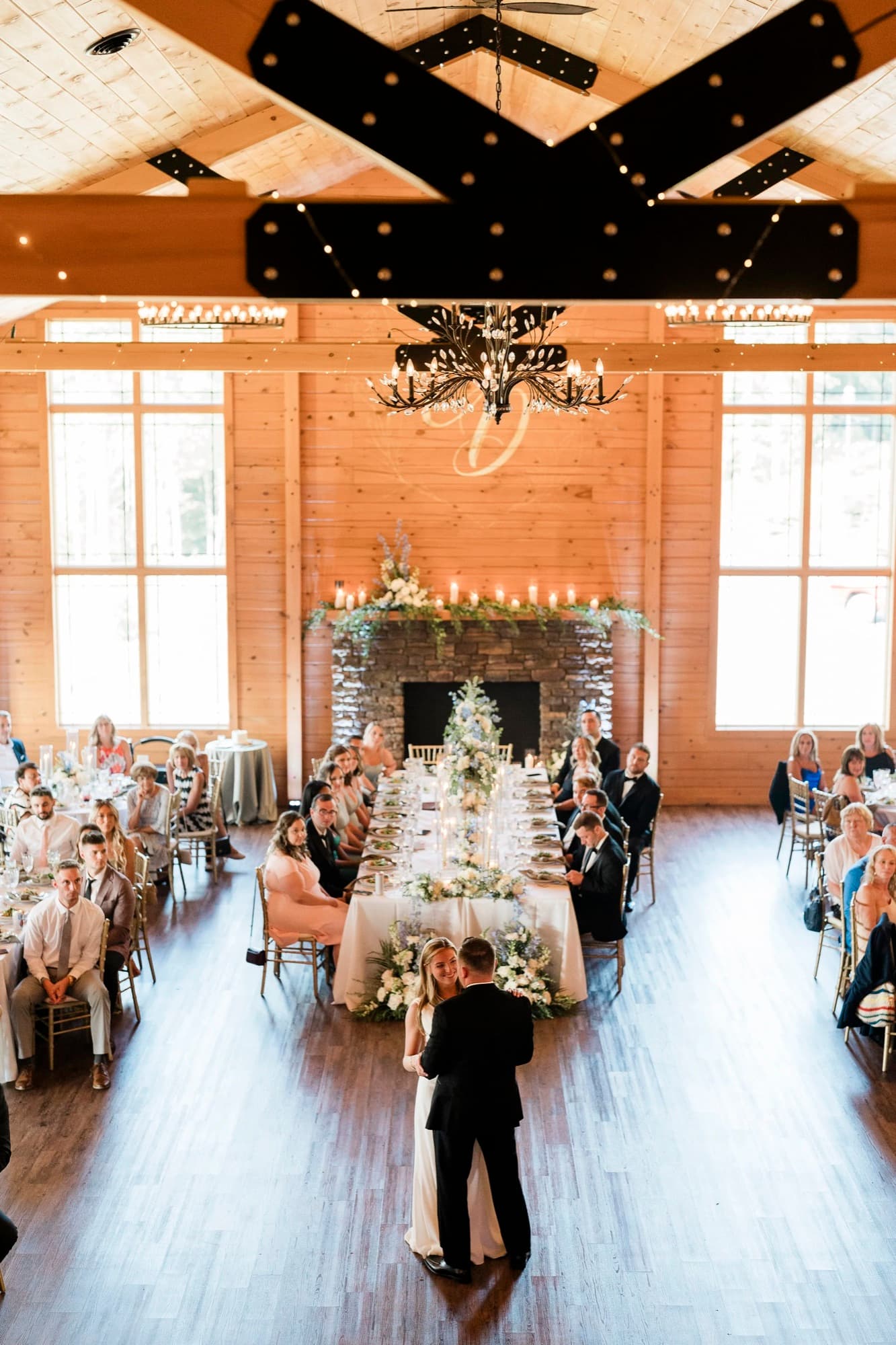 Long tables set inside a barn reception
