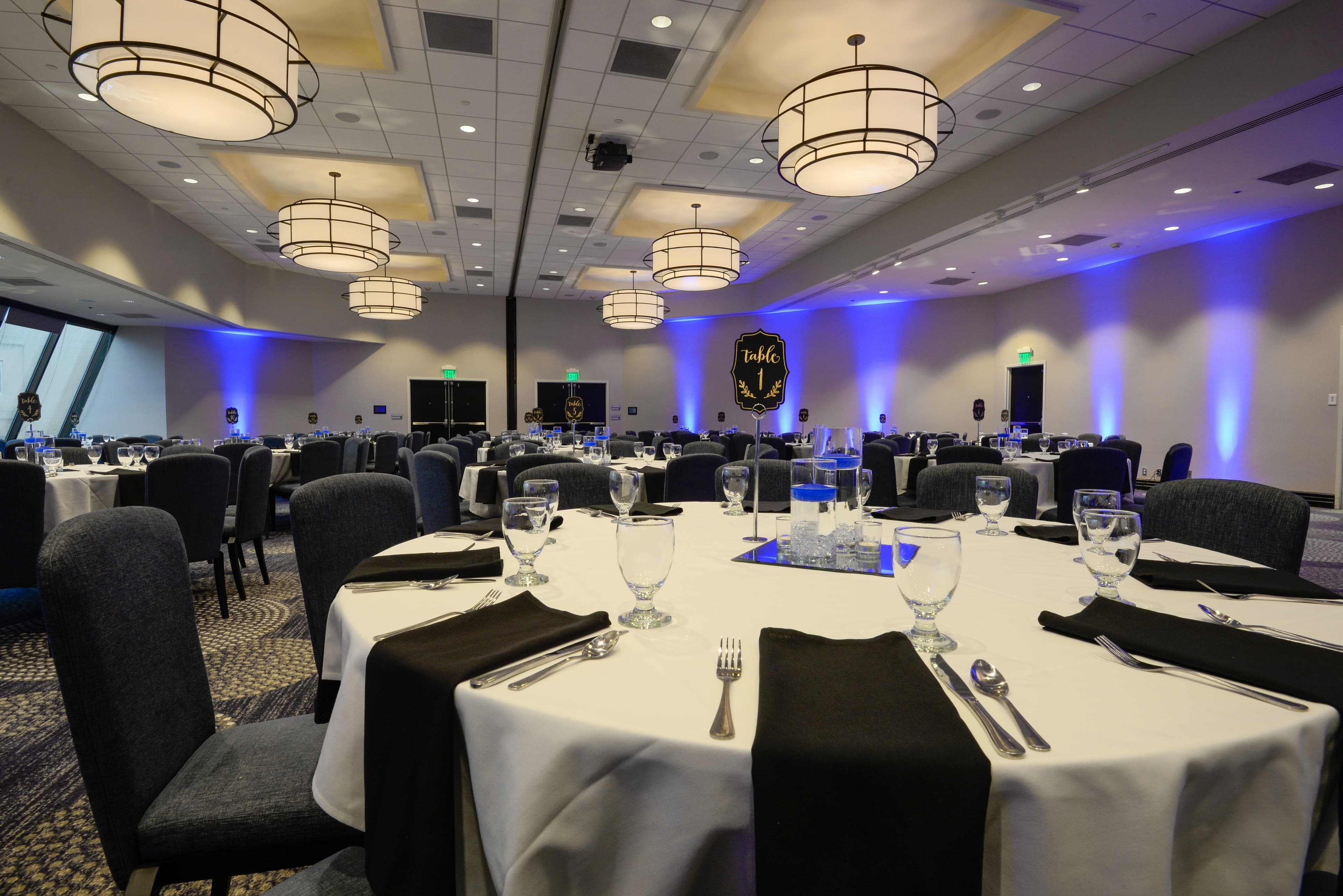 Banquet room with round dining tables and blue uplighting