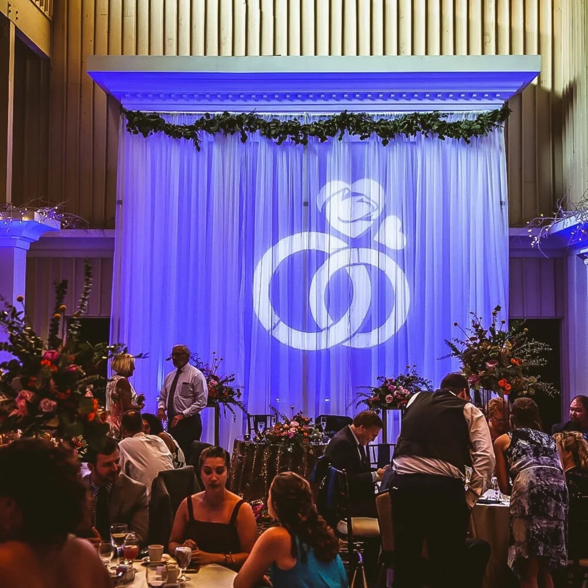 Uplighting and a projected monogram over a reception room