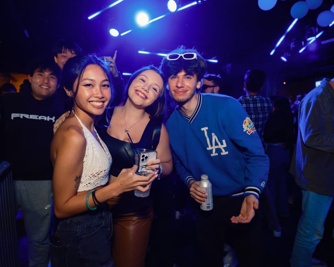 Friends enjoying a night out beneath blue club lights